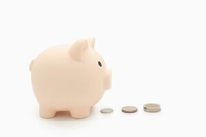 The Piggy Bank follows the coin to collect the money in isolated background. saving money wealth and financial concept, Business, finance, investment, Financial planning. Follow a plan to save money. photo