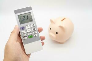 Remote control of air conditioner with Piggy bank. Try to save money on electricity. photo