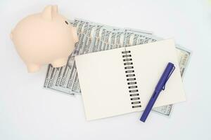 dinero presupuesto planificación. cerdito banco con cuadernos en blanco fondo, financiero objetivo concepto. foto