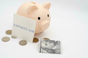 concept of emergency savings fund. A piggy bank with dollar and coins. piggy bank for saving emergency money.Saving for emergency concept. isolated background. photo