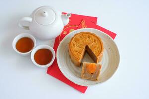 Top view of Chinese Mid-Autumn Festival concept made from mooncakes, tea decorated and red envelopes isolated on white background. photo