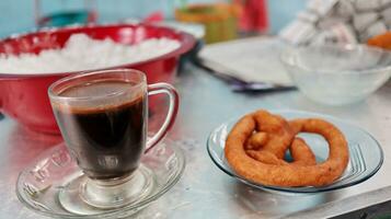 a glass of black coffee and snacks photo