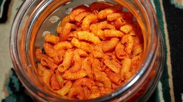 Red Spicy Fried Macaroni Texture in a glass container photo