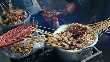 el proceso de ardiente satay en el ardiente carbones foto