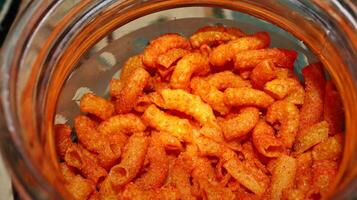 Red Spicy Fried Macaroni Texture in a glass container photo