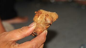 Hold fried chicken pieces on blur background photo