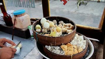 Street food, steamed dumpling dimsum in traditional bamboo steamer. Siomay photo