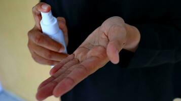 Hand of lady that applying alcohol spray or anti-bacteria spray to prevent the spread of germ photo