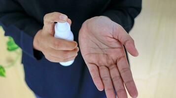 Hand of lady that applying alcohol spray or anti-bacteria spray to prevent the spread of germ photo