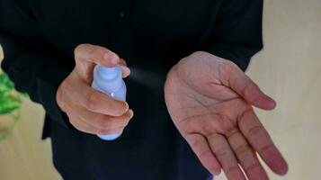 Hand of lady that applying alcohol spray or anti-bacteria spray to prevent the spread of germ photo