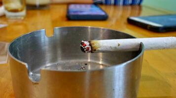 Cigarettes in ashtray at smoking are photo