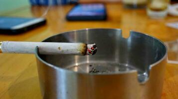 Cigarettes in ashtray at smoking are photo