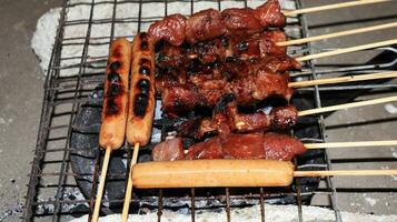 sausages and meat grilled over the fireplace with spicy soy sauce photo