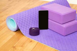 Blank phone on yoga mat with blocks and strap photo