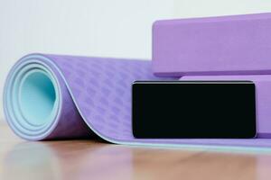 Blank phone on yoga mat with blocks photo