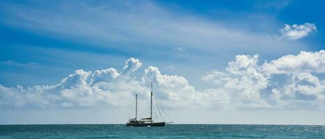 Passing sailing boat near the shore of the north east point of Mahe, Seychelles photo