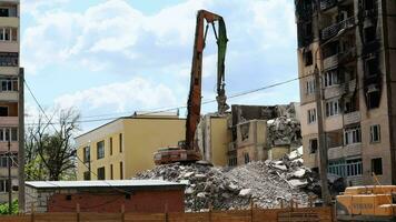 a processo do desmantelamento a velho prédio. a escavadora rompe a casa. demolição do dilapidado habitação. construção escavadora demolir a casa. Ucrânia, irpin - pode 12, 2023. video