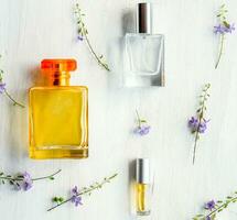 Aromatic Perfume bottles set and flower on the white wooden desk on at wooden background photo