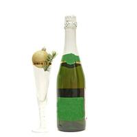 A bottle of champagne and empty glass with Christmas toys isolated on white background photo