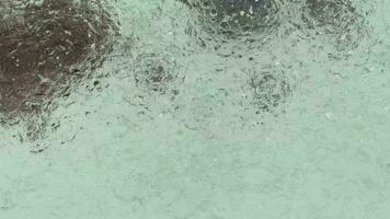 regen vallend Aan de fontein zwembad, 4k video