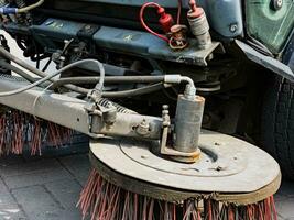 Broom of Road Sweeper Car Machine Close-up. Concept clean streets from debris. photo