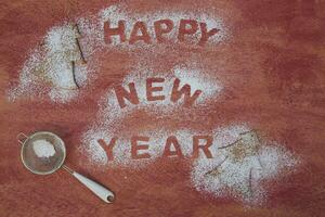 happy new year text with sugar and a spoon on a red background photo