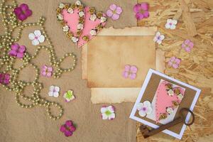 a wooden table with a card, a key, and some flowers photo