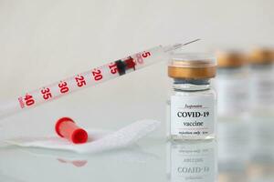 vaccine and syringe on a table photo