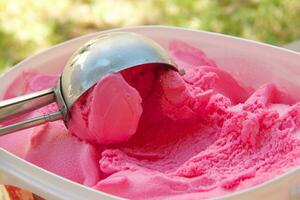 pink ice cream next to a spoon photo