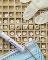 covid-19 testing kits and medical gloves on a wooden board photo