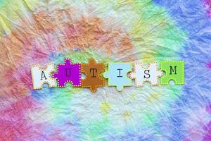 the word autism on colorful tie dye fabric photo