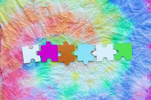 colorful puzzle pieces on a colorful tie dye background photo