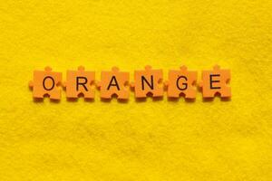 orange word on yellow background with jigsaw puzzle pieces photo