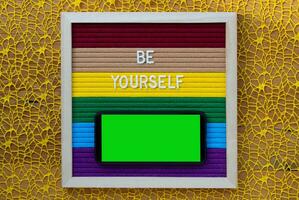 be yourself text on colorful paper frame on yellow background photo