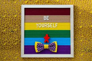 be yourself text on colorful paper frame on yellow background photo