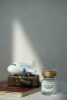 un tarro de crema siguiente a un maleta y un avión foto