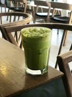 A green drink sitting on top of a table photo