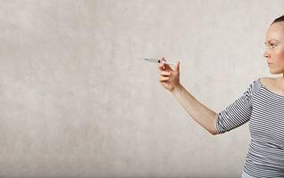 a woman holding a syringe in her hand photo