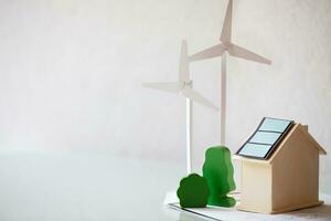 a small house with wind turbines and a solar panel photo