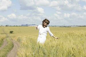 a woman in a white dress standing in a field photo