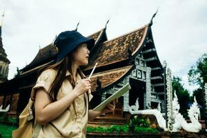 Asian traveller woman with tablet at ok moli temple in Chiang Mai province, Thailand photo