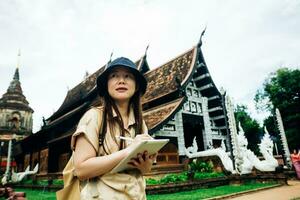 Asian traveller woman with tablet at ok moli temple in Chiang Mai province, Thailand photo