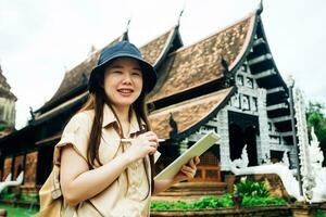 Asian traveller woman with tablet at ok moli temple in Chiang Mai province, Thailand photo