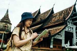 Asian traveller woman with tablet at ok moli temple in Chiang Mai province, Thailand photo