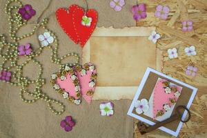 a heart and a key are on a wooden table with flowers and beads photo