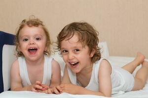 dos niños tendido en un cama foto