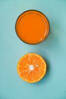 Flat lay of a few pieces of orange fruit on a blue table background photo