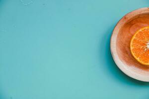 Flat lay of a few pieces of orange fruit on a blue table background photo