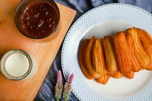 churros, traditional Spanish food served with chocolate and warm milk on the table photo