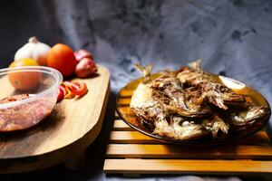 fried mackerel fish served on a plate with spicy sauce photo